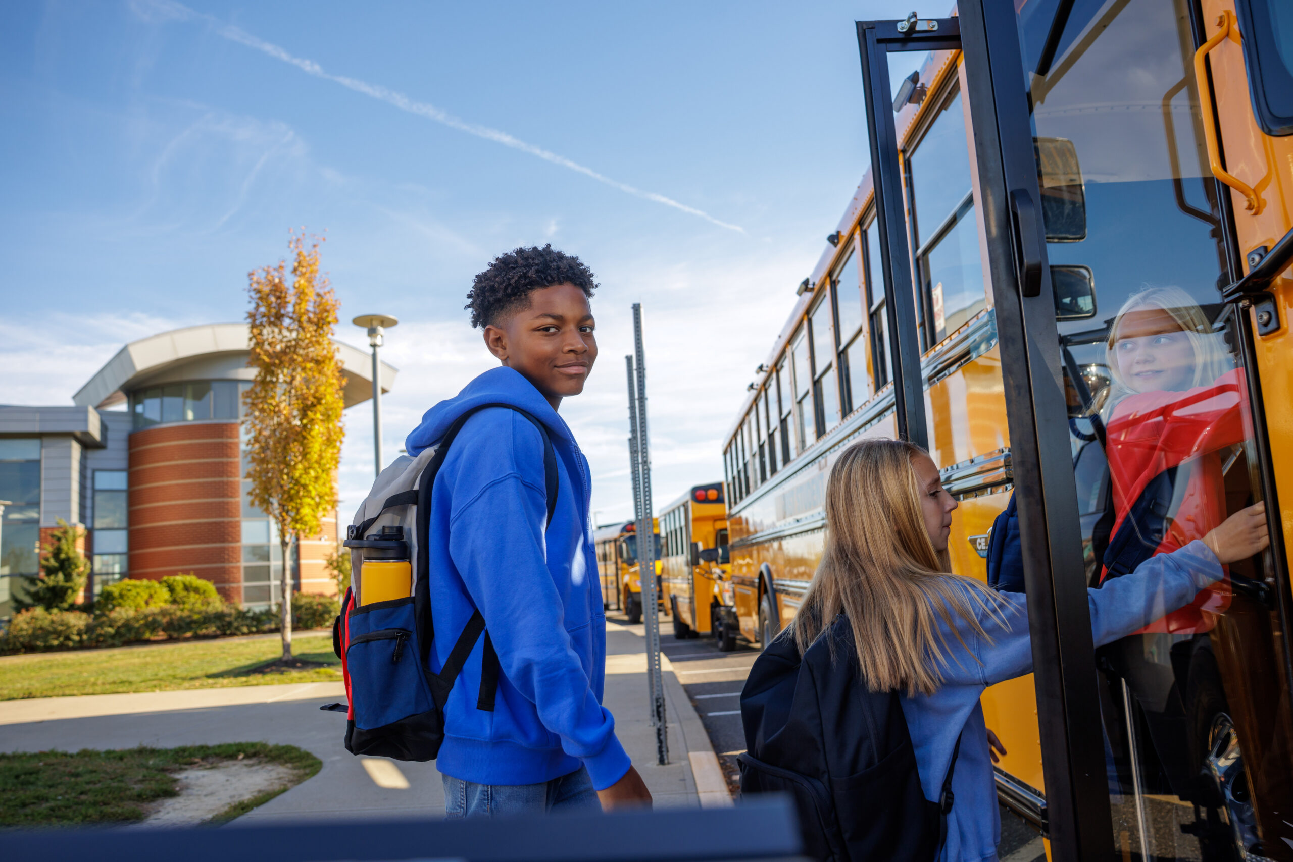 Boy and girl getting on bus
