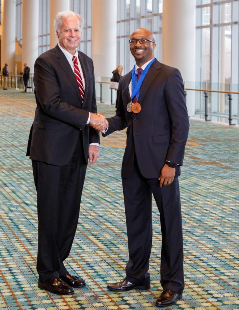 First Student CEO Paul G. Osland shakes hands with 2022 AASA National Superintendent of the Year Curtis Cain.