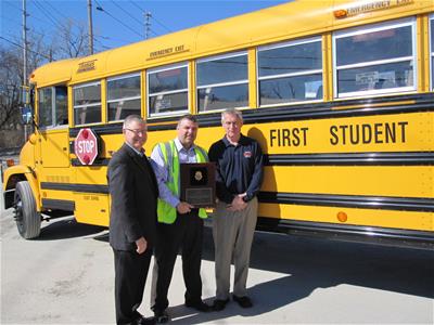 Man Given Award in Front of School Bus